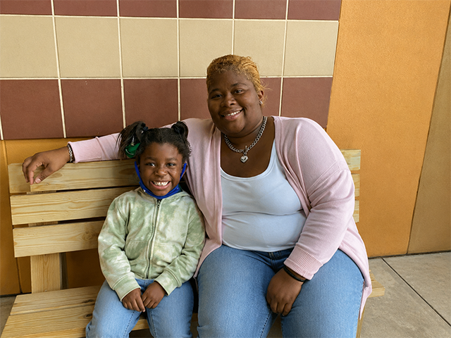 mother and daughter sitting on a bench